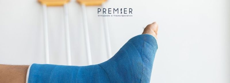 A blue cast and crutches in the background show healing broken bone as the patient wonders if they will deal with life long disability or pain after their fracture. Premier Orthopaedic & Trauma Specialists weigh in on what to expect after a fracture.