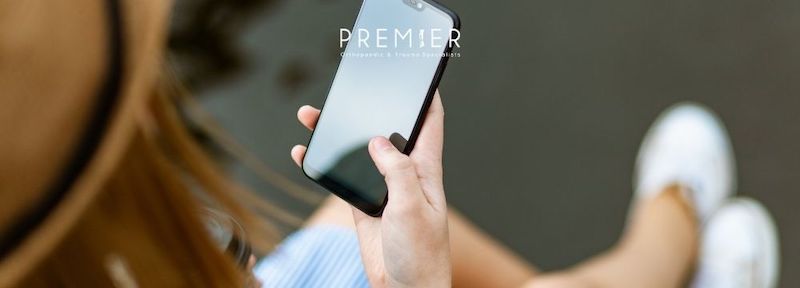 Woman on smartphone could be experiencing pain from smartphone tendonitis according to Premier Orthopaedic & Trauma Specialists