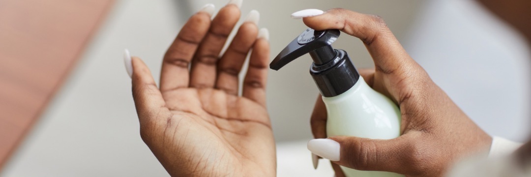 Woman putting lotion onto hands